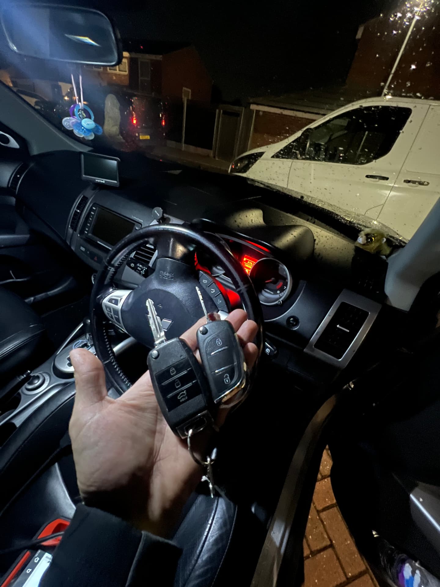 Keys held at the steering wheel inside a Mitsubishi during key programming